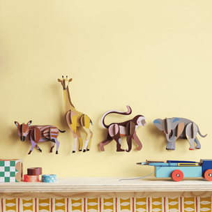 Colorful animal-shaped hooks on a yellow wall above a shelf with toys.
