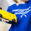 Child playing with Doc Ryder Yellow & Black Wooden Car | Conscious Craft