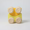 Grimm's Yellow toy car with wooden wheels on a light gray background