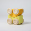 Grimm's Wooden toy car  with yellow top and square base on a light gray background