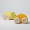 Wooden toy truck with a yellow bed and orange body on a light gray background