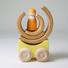 Grimm's Wooden toy car with a small figure and circular elements on a light gray background