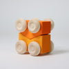 Grimm's Wooden toy car with orange body and beige wheels on a light gray background