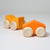 Grimm's Two orange wooden toy cars with beige wheels on a light gray background