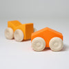 Grimm's Two orange wooden toy cars with beige wheels on a light gray background