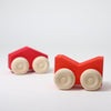 Grimm's Two red wooden toy cars with beige wheels on a white background