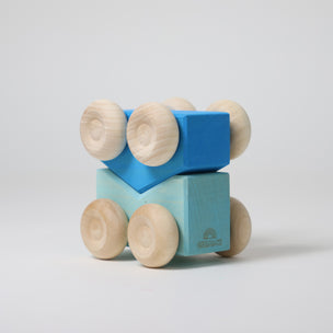Grimm's Wooden toy car with blue blocks and beige wheels on a light gray background