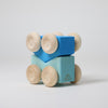 Grimm's Wooden toy car with blue blocks and beige wheels on a light gray background
