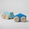 Grimm's Two blue wooden toy cars with beige wheels on a light gray background