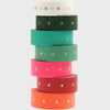 Stack of colorful washi tape rolls with star patterns on a white background