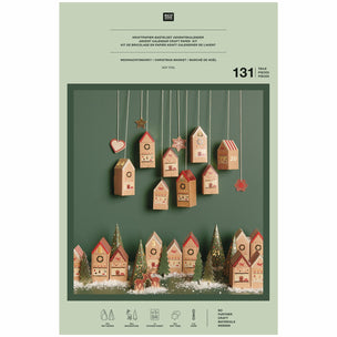 Wooden Christmas village set on a green packaging with product details.