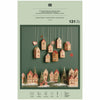 Wooden Christmas village set on a green packaging with product details.