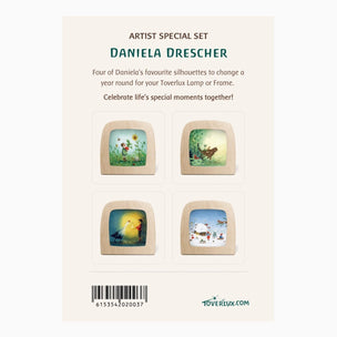 Back of a Daniela Drescher artist special set card for Toverlux, showing four illustrated wooden lamp frames with floral and winter scenes, plus barcode and Toverlux branding on a cream background.
