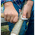 Person using a knife to cut a branch with a blurred background