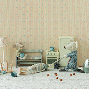 Miniature Maileg mouse cleaning a room with toys and furniture against a patterned wall.