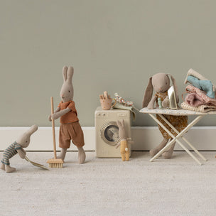 Set of toy Maileg rabbits  engaged in a laundry scene with a washing machine, dryer, and ironing board.