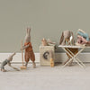 Set of toy Maileg rabbits  engaged in a laundry scene with a washing machine, dryer, and ironing board.