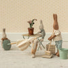 Miniature Maileg scene with toy bunnies engaged in cleaning activities on a neutral background