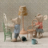 Two toy mice in a miniature room with furniture and decor.