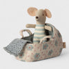 Maileg  mouse toy in a floral carry cott with a blanket on a light background