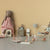 Children's playroom with Maileg toy furniture and stuffed animals on a beige wall background