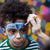 Child with face paint being applied against a colorful blurred background