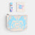 Pouch with blue fox design, lip balm, and notebook on a white background