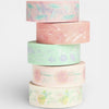 Stack of pastel-colored washi tape rolls with floral patterns on a white background