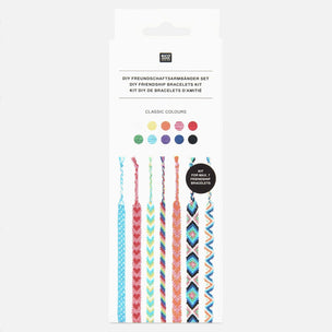 A retail package of a DIY friendship bracelet kit. The white cardboard box features German and English text, a 'moy' brand logo, a 'CLASSIC COLOURS' label with ten color swatches, and illustrations of four colorful woven friendship bracelets at the bottom.