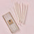 Set of white candles with packaging on a pink background