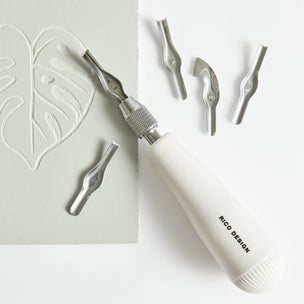 White carving tool with interchangeable heads on a white background
