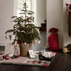 Decorated Christmas tree in a room with toys and a fireplace.