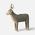 A sculptural Maileg deer-shaped candle holder with a matte beige finish and a small brass candle holder slot on its back, shown against a light gray background.