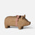 A small wooden Maileg pig figurine candle holder with a natural light brown finish, featuring a red and white gingham ribbon tied around its neck and a brass coin slot on its back, set against a plain light gray background.