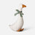 A white Maileg goose-shaped decorative figure with an orange beak and feet, wearing a green patterned bow around its neck, photographed on a clean light gray background.
