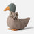 A plush Maileg duck-shaped decorative pillow or toy in textured taupe fabric, featuring a muted green head, orange beak and feet, and a floral-patterned bow tie, photographed on a light gray background.