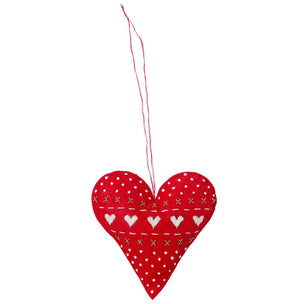 A red heart-shaped fabric hanging ornament with white embroidered hearts, dots, and stitched lines, suspended by a thin red string against a plain white background.