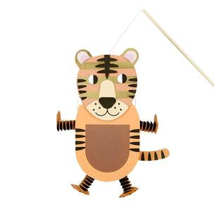 A hanging tiger-shaped wall art or decorative panel with a wooden rod, featuring layered tan, beige, brown, black, and muted green tiger face and body details on a plain white background.