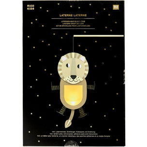 Rico Kids laser-cut wooden lion lantern in its black retail packaging, featuring a starry night sky background and a golden-yellow glowing lion illustration on the front.