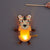 A tiger-shaped hanging paper lantern with a glowing warm light inside, suspended by a string and held by a wooden stick, against a plain gray background. A person's hand is visible at the top right holding the stick.