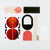 A flat-lay view of a ladybug craft kit containing various colored paper pieces, wooden sticks, and a white sheet on a clean white background.
