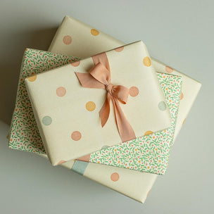 Three gift boxes with patterned wrapping paper and ribbons on a light gray background