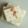 Three gift boxes with patterned wrapping paper and ribbons on a light gray background