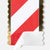 A close-up of a rectangular card or label with a red and white diagonal stripe design and scalloped gold edges, showing a peeled white backing at the bottom on a light gray background.