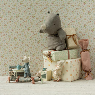 Maileg Rhino with gift boxes against a floral wallpaper background