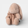 Plush bunny toy with a bow on a light gray background
