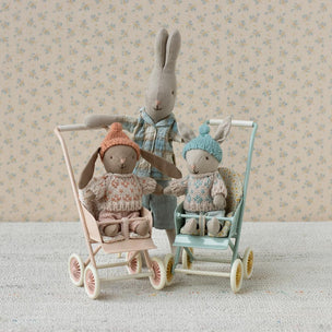 Maileg Two toy bunnies in strollers with a floral wallpaper background