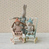 Maileg Two toy bunnies in strollers with a floral wallpaper background