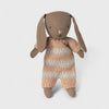 Knitted tMaileg rabbit with a striped sweater on a light gray background