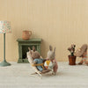 Miniature scene with Maileg bunnies in a room setting, including a lamp, fireplace, and decorative items.